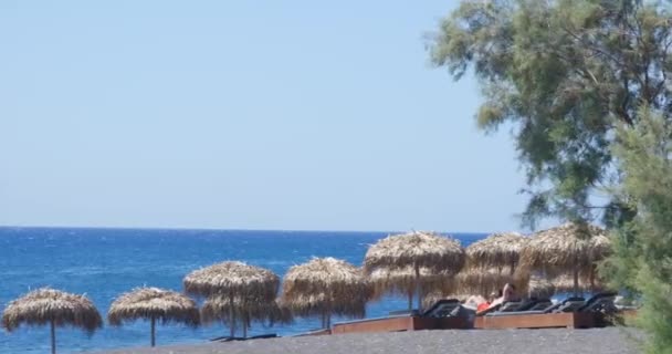 Menschen Liegen Auf Sonnenhütten Klaren Strand Auf Santorin Griechenland — Stockvideo