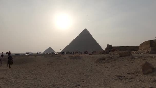 日落时分吉萨金字塔与烟雾的神秘景象 骑马的游客 — 图库视频影像