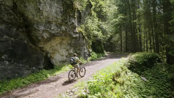 Yaz Boyunca Yeşil Dağlarda Kayalık Yolda Bisiklete Binen Erkek — Stok video