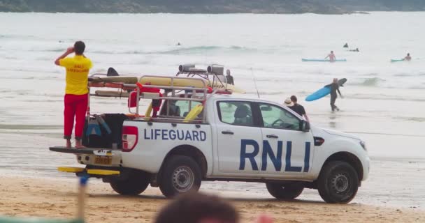 Rnli救生员通过巡逻车的双筒望远镜监视海上人员 英国康沃尔 Fistral Beach Newquay Cardihoto Shot — 图库视频影像