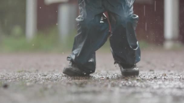 Slow Motion Ett Barn Med Ett Paraply Hoppar Lerig Pöl — Stockvideo