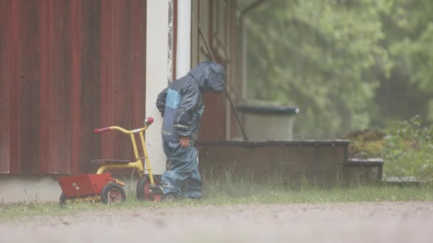 Slow Motion Cute Child Plays Downpipe Heavy Rainfall — Stock Video