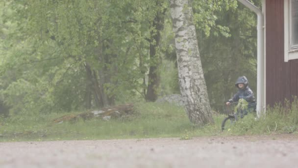 Moción Lenta Niño Pequeño Montando Bicicleta Fuertes Lluvias — Vídeos de Stock