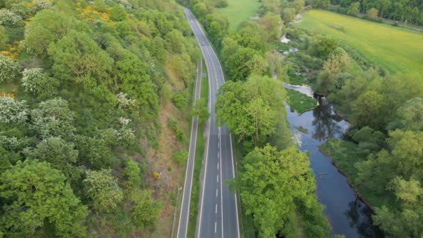 Two Cars Travelling Countryside Highway Lush Deciduous Forests Calm Blue — Video Stock