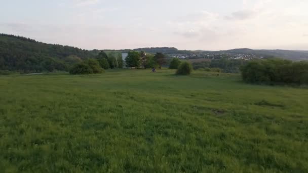 Motorcyclist Standing Expansive Lush Meadow European Countryside Fast Aerial Pull — Stockvideo