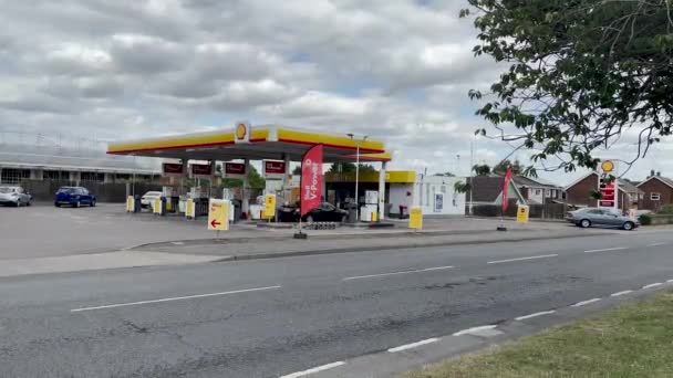 英国サフォークのBury Edmundsの忙しい道路の隣に高価な燃料を持つShell Garage — ストック動画