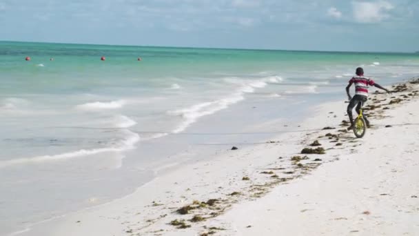 Black Kid Pedaling Monocycle Sea Waves Sand Beach Zanzibar — Stockvideo