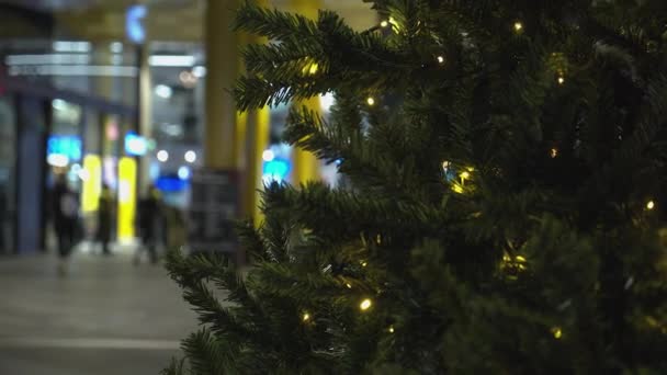 Close Christmas Tree Defocused Festive Shoppers Background — Stockvideo