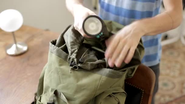 Een Man Steekt Een Zaklamp Zijn Groene Rugzak Sluit Deze — Stockvideo