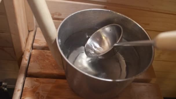 フィンランド式サウナでは 金属製の桶と柄杓でお湯を入れていました — ストック動画