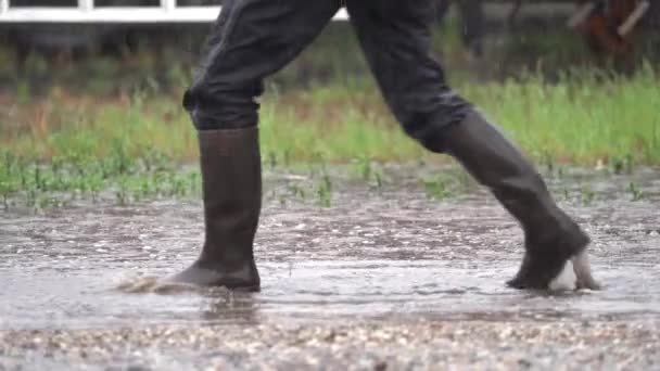 Hravý Dospělý Člověk Gumových Botách Kopne Puddle Pod Deštěm Střední — Stock video