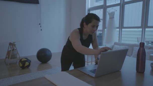 Seorang Wanita Membuka Komputernya Untuk Memulai Pekerjaan Rumah Ruang Tamunya — Stok Video
