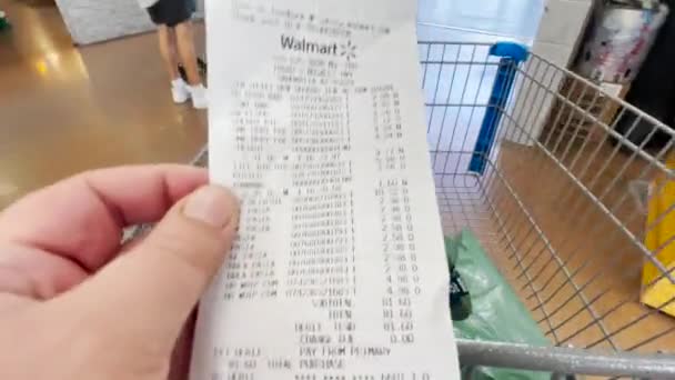 Споживач Дивиться Рахунок Продуктами Після Покупки Walmart Штовхаючи Візок Глобальна — стокове відео