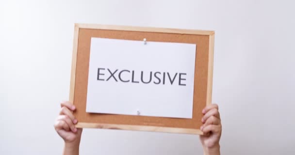 Woman Hand Shows Paper Board Word Exclusive White Studio Background — Stockvideo