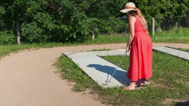 Lady Red Dress Misses Golf Club Swing Practicing Mini Golf — Vídeos de Stock