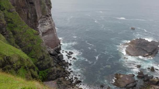 Slow Tilting Panning Shot Rising Rocky Bay Waves Lap Tall — стоковое видео