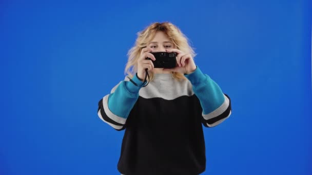Молодая Блондинка Студентка Программы Обмену Фотографируется Кинокамерой Фоне Синего Экрана — стоковое видео