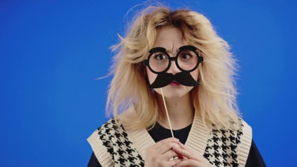 Goofy Caucasian Blonde Woman Holding Mustache Glasses Stick Face Blue — Stockvideo