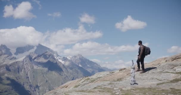 スイスのマッターホルン近くの山の端から歩いていく黒人男性旅行者 — ストック動画