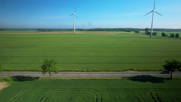 Воздушная Съемка Электромобиля Движущегося Сельской Дороге Вращающегося Ветрогенератора Заднем Плане — стоковое видео
