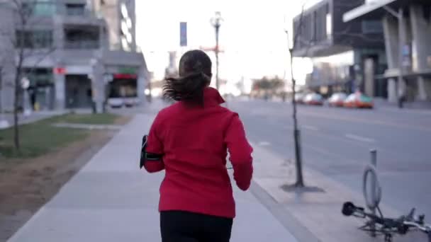 Shot Woman Red Hoodie Jogging Sidewalk Next Street — Stockvideo