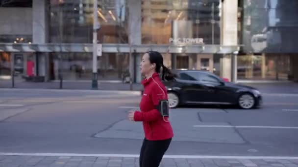 Woman Red Hoodie Jogging Sidewalk Next Street — Stockvideo