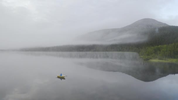 Person Blue Jacket Sitting Rowing Boat Middle Big Lake Mist — Vídeo de Stock