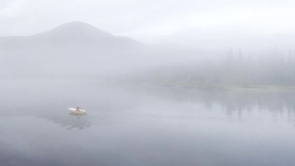 Aerial View Man Rowing Boat Calm Mist Filled Lake Mountain — Vídeo de Stock