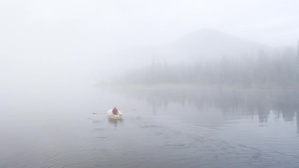 Person Rowing Boat White Foggy Lake Landscape Mountain Forest Background — стоковое видео