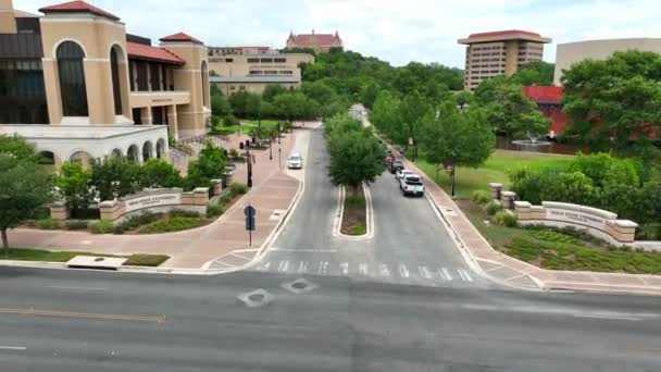 テキサス州立大学のキャンパス 交差点での驚くべき上昇ショット 大学の建物や水を明らかに — ストック動画