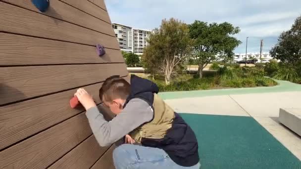 Boy Climbs Rock Wall Located Public Park Australia Side View — Stock Video