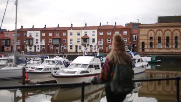 Μια Γυναίκα Στέκεται Δίπλα Ένα Φράχτη Κοιτάζοντας Αγκυροβολημένα Πλοία Στο — Αρχείο Βίντεο
