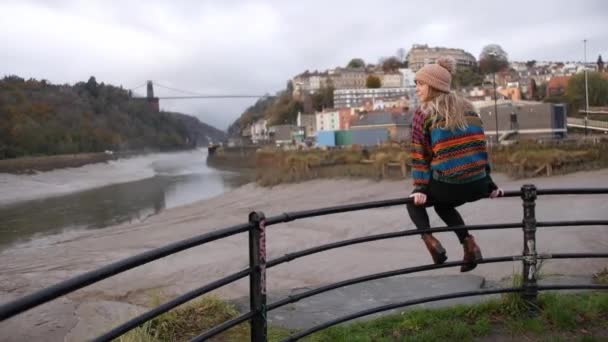 Girl Sitting Fence Watterside Watching Suspense Bridge Bristol — Video Stock