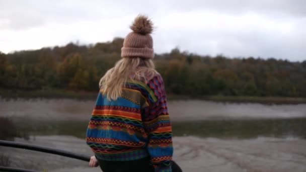 Girl Colourful Sweater Beanie Hat Sitting Fence Looking Suspension Bridge — Stok video