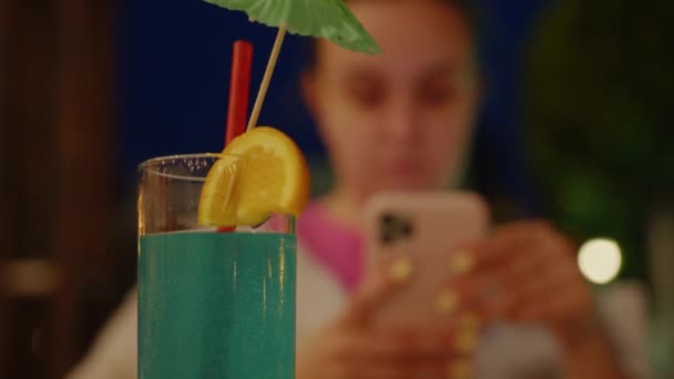 Woman Using Smartphone Sits Front Blue Drink Straw Umbrella — Vídeo de Stock