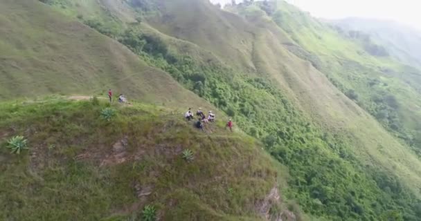 Люди Сидящие Вершине Холма Наслаждаются Видом После Восхождения Спиральный Выстрел — стоковое видео