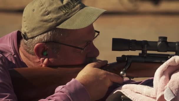 Well Seasoned Hunter Smiles Hits Target While Sighting His Gun — Stock Video