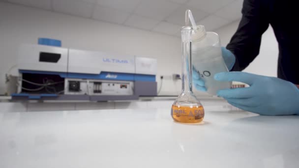 Man Gloves Adds Water Glass Flask Orange Liquid Lab — Stockvideo