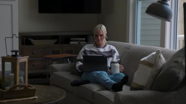 Woman Sitting Couch Front Bay Window Drinking Coffee While Scrolling — Stok video