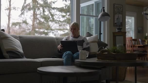 Woman Sitting Couch Front Bay Window Drinking Coffee While Scrolling — Stok video