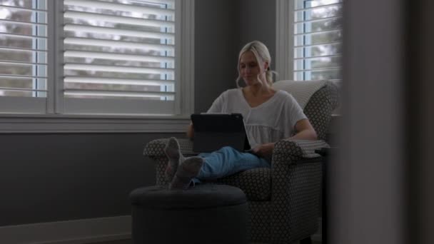 Женщина Сидящая Стуле Углу Читального Зала Прокручивая Планшете Ноги Стуле — стоковое видео