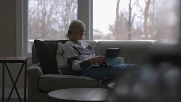 Woman Sitting Couch Front Bay Window Drinking Coffee While Scrolling — Stok video
