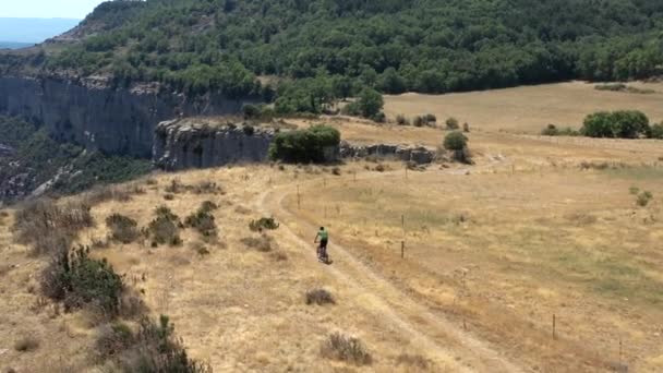 Mountain Bike Rider Peacefully Descending Golden Summer Landscape Close Cliff — Stockvideo