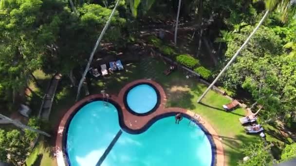 Pull Back Shot Person Jumping Unique Pool Design Surrounded Green — Vídeo de stock