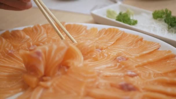 箸で生の鮭の刺身を日本料理店で選びます アジア料理 — ストック動画