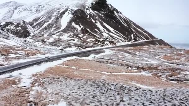 冬のアイスランドの海岸線を走るアイスランドの雪景色と車による空中飛行 Djpivogur — ストック動画