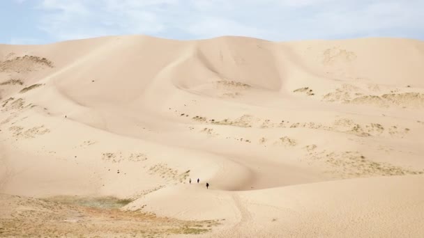 Aerial Dolly Three People Walking Sand Dune Gobi Desert Daytime — Stock video