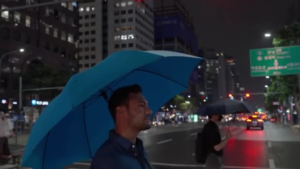 Tracking Shot Barbudo Joven Umbrella Walking Zebra Downtown Seoul Night — Vídeo de stock