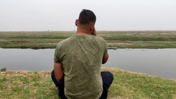 Задняя Часть Мальчика Сидящего Позе Лотоса Перед Морем Медитирует Молится — стоковое видео
