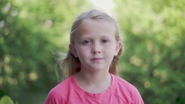 Une Jeune Fille Blonde Regarde Caméra Ralenti Avec Des Arbres — Video